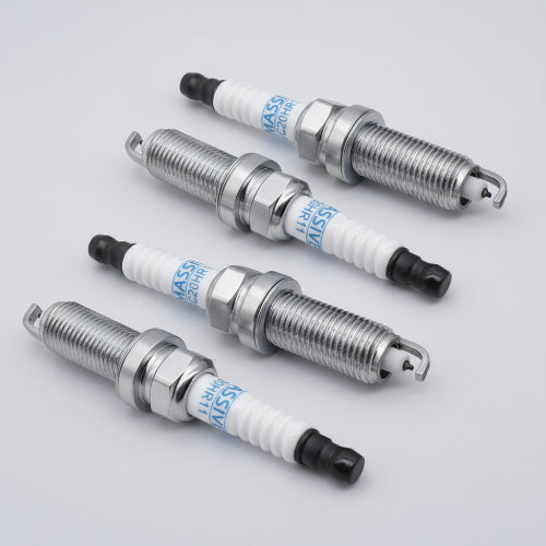 Set of four spark plugs for Toyota Prius V 2016 ZVW50, with metal threaded body, white ceramic insulator, and black tip, used for engine ignition.